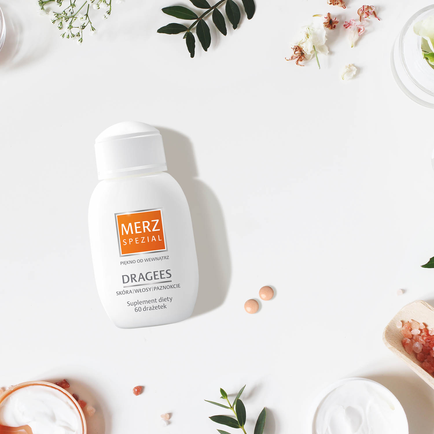 Styled beauty frame, web banner. Skin cream, tonicum bottle, dry flowers, leaves, rose and Himalayan salt. White table background. Organic cosmetics, spa concept. Empty space, flat lay, top view.